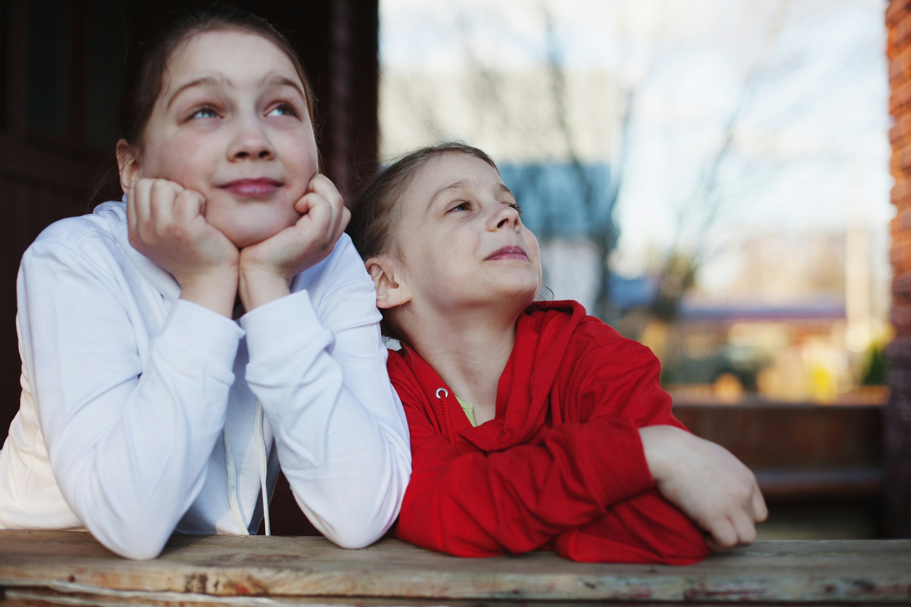 Two kids looking out thoughtfully